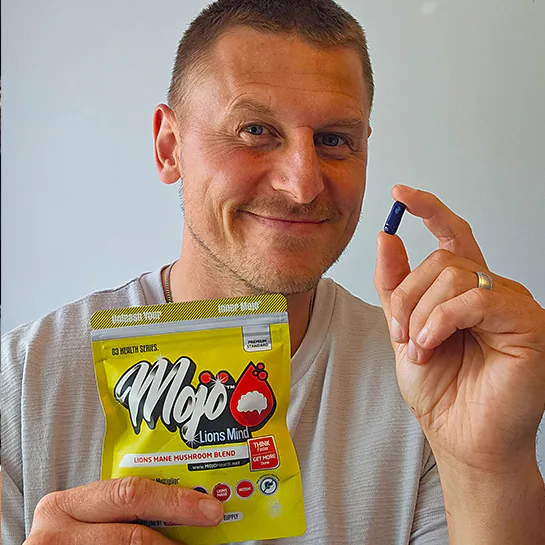 A customer holding a MOJO™ LIONS MIND capsule and pouch