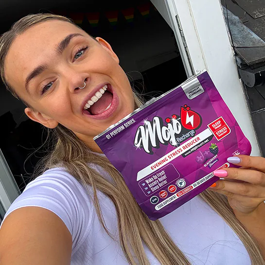 A customer holding a pouch of MOJO™ RECHARGE sleep gummies
